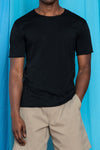Waist-up image of Torey wearing the Dreamweight Raw Cut Shortsleeve in Black and the F.Cloth Bigs in Sandstone