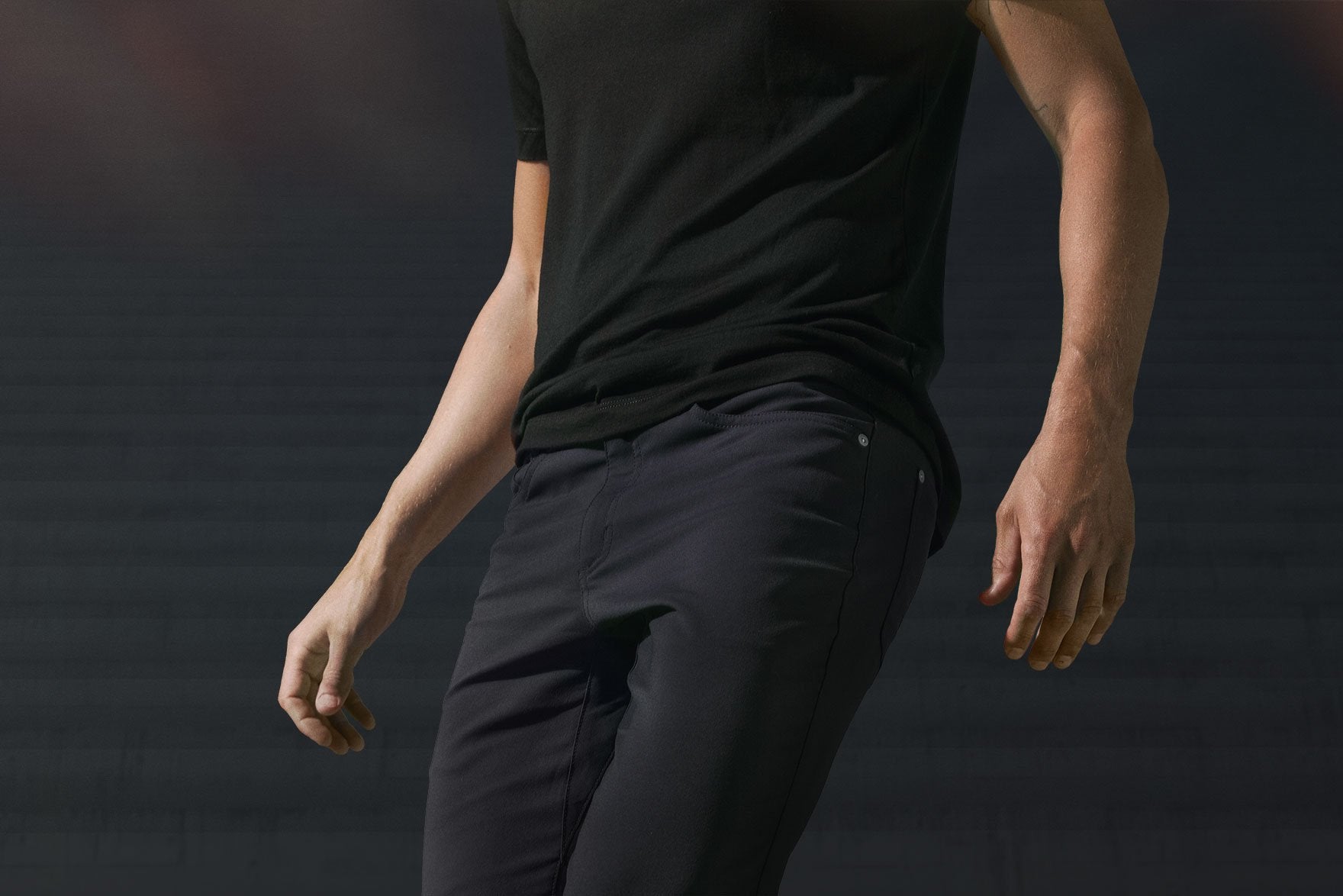 John Paul, chest to thighs, arms raised slightly at sides, wearing Slim Dungarees in Charcoal and our Ultrafine Merino Cut One T-Shirt in Black.