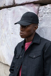 Edem leaning back on a concrete wall in the Duckcloth Shank Jacket